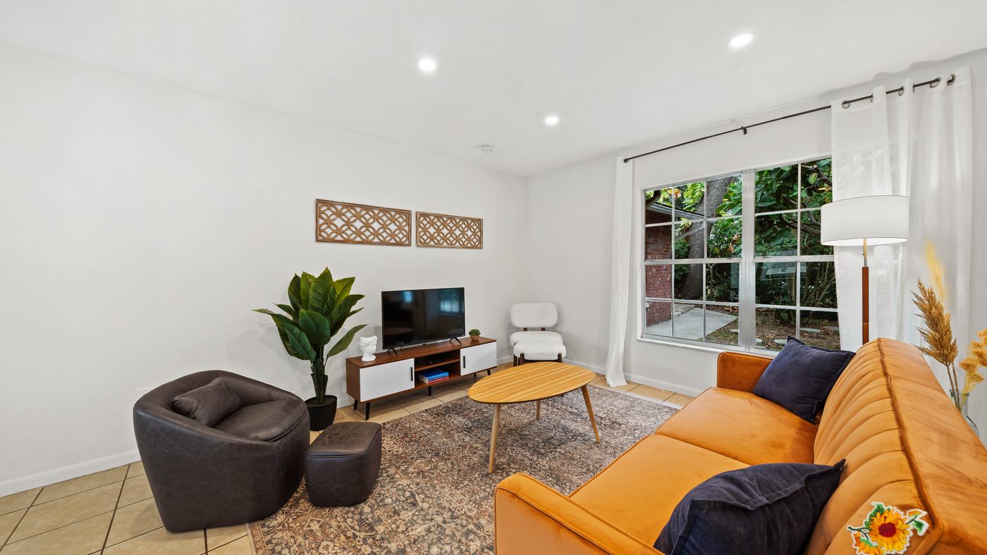 Bright living room with an orange sofa at The Oasis